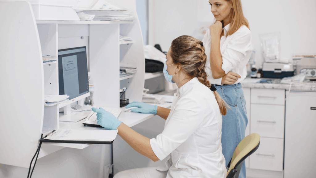 A doctor showing a patient their health information on a computer screen.