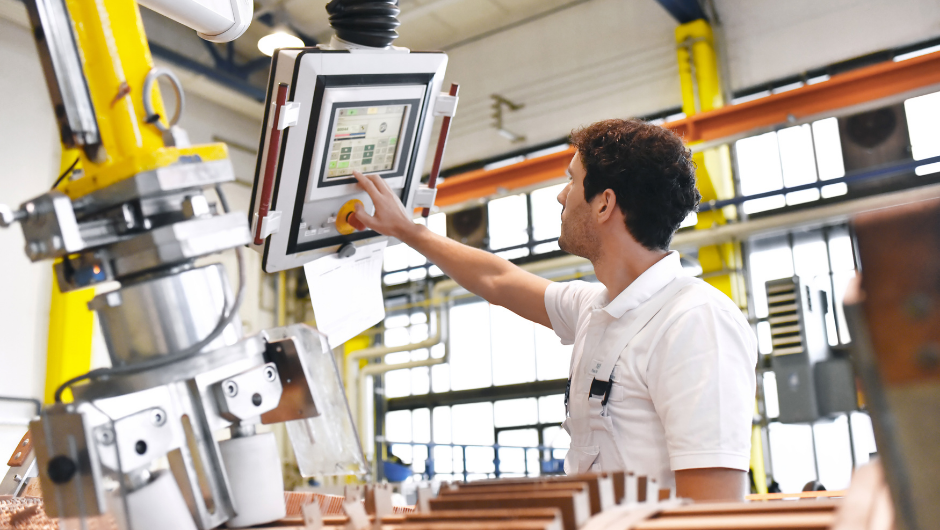 A Michigan plant worker using IT touchscreen system in manufacturing.