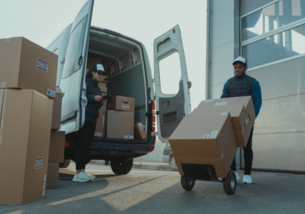 logistics company employees unloading boxes from a truck