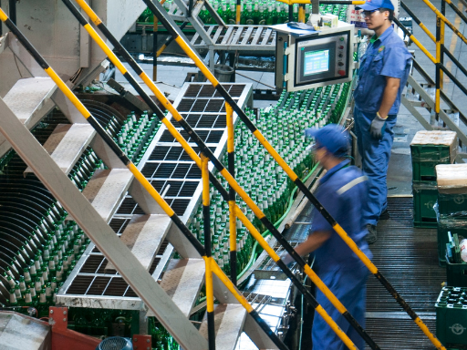 Workers operating a large machine within a food manufacturing plant.